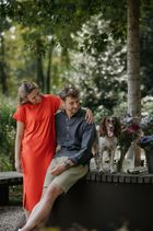 Foto van Anne en Bram, de bezielers van Fieflora, met hun hond en een boeket bloemen